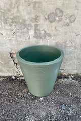 The olive 20" Madison planter against a concrete wall shown from above and the side. 