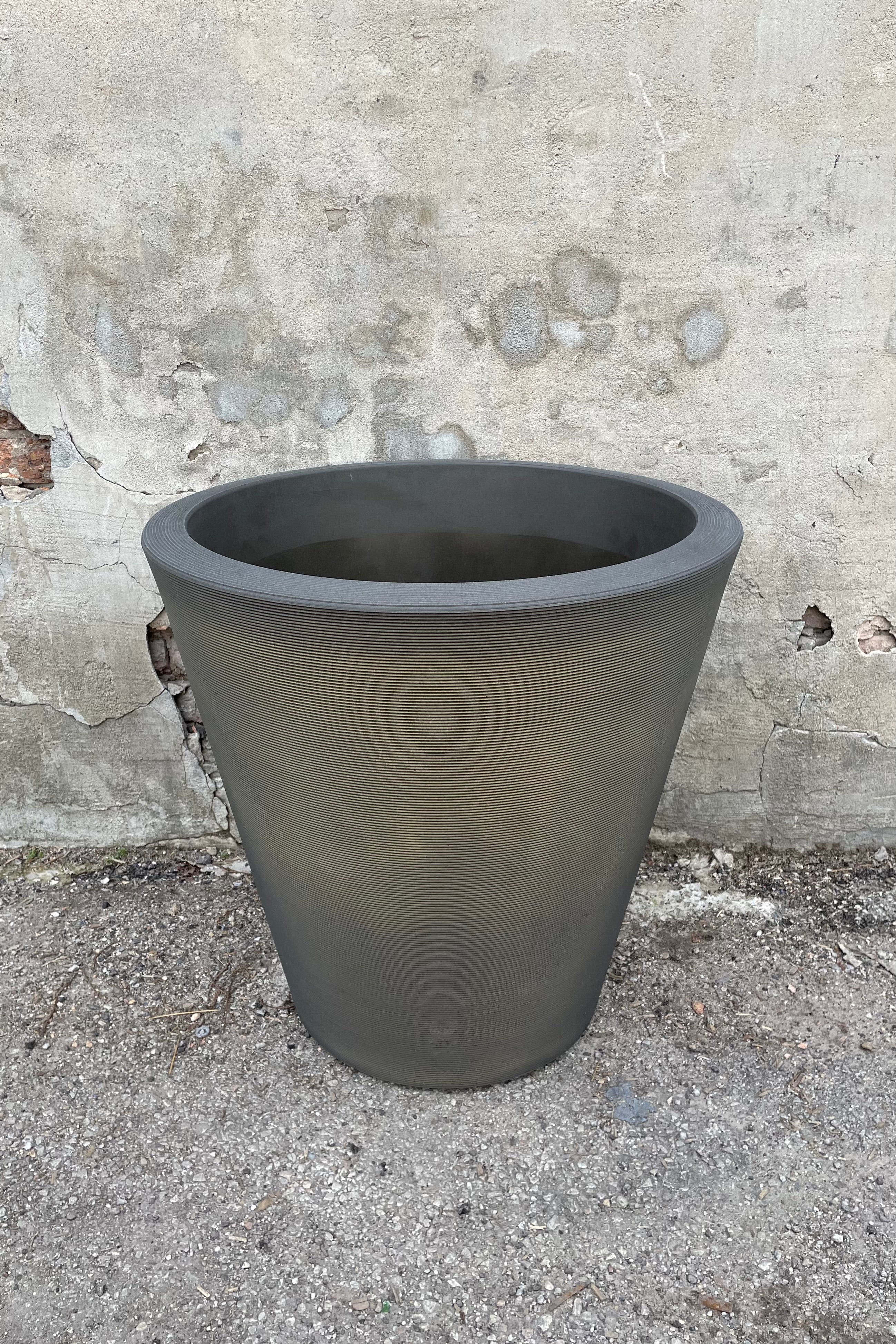 The old bronze Madison pot in 26" against a cement wall. 