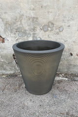The old bronze Madison pot in 26" against a cement wall. 