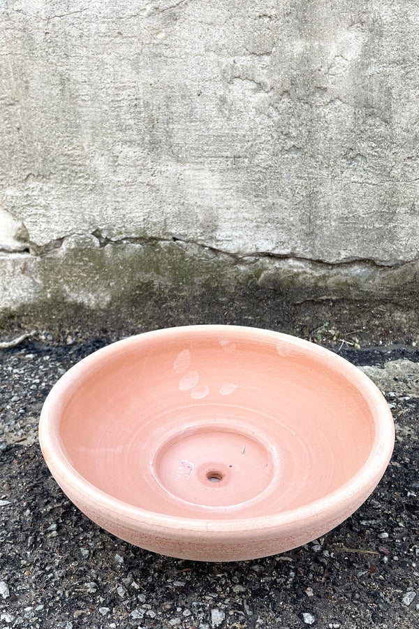 An overhead view of Ada Clay Bowl & Saucer rosa 30cm against concrete backdrop