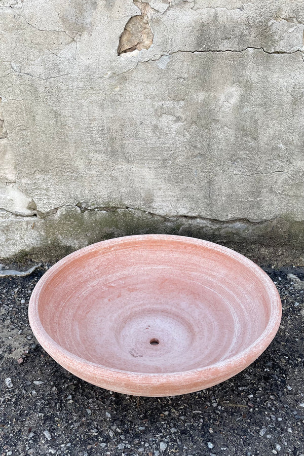 An overhead view of Ada Clay Bowl & Saucer rosa 40cm against concrete backdrop