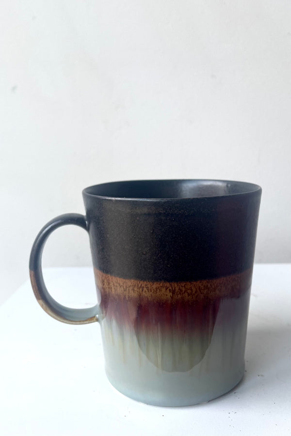 A frontal full view of Mug black & golden glaze against white backdrop