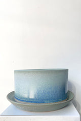 A frontal view of Atlas Planter & Saucer blue stone against a white backdrop