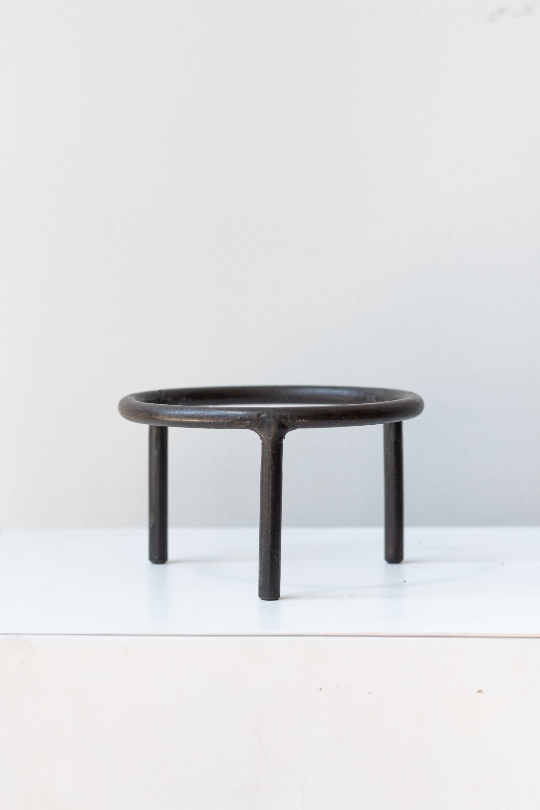 4 inch iron metal tripod pot stand on a white surface in a white room ©Sprout Home