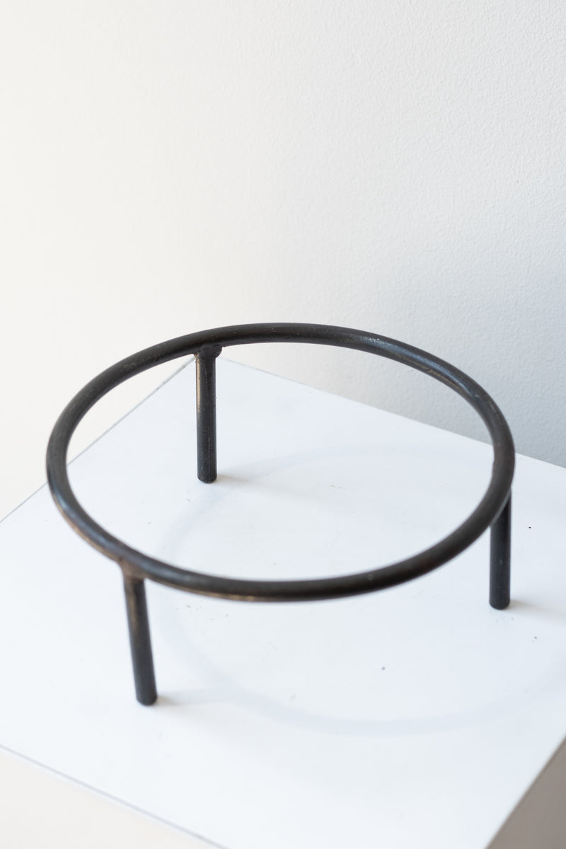 6 inch iron metal tripod pot stand on a white surface in a white room