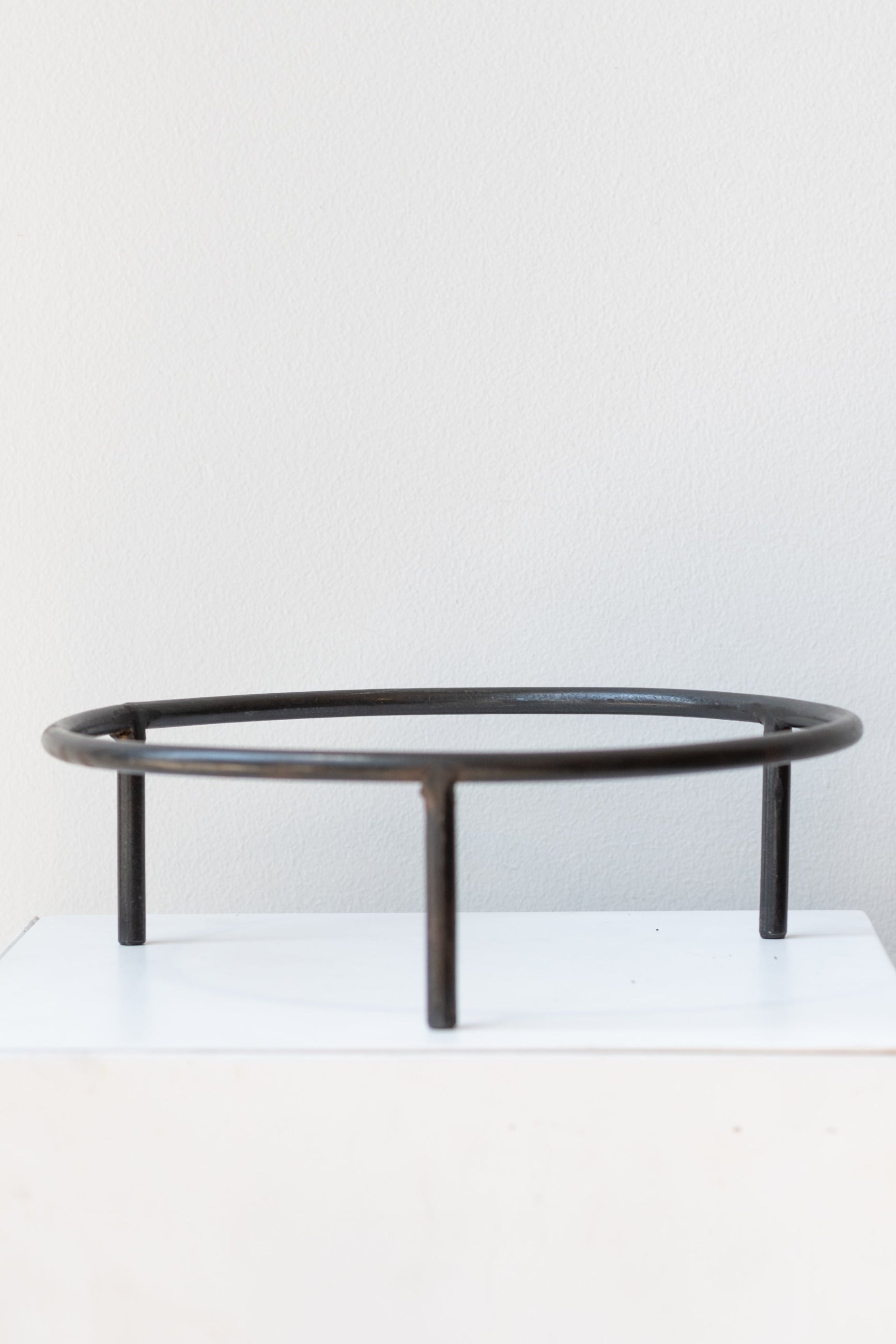 8 inch iron metal tripod pot stand on a white surface in a white room ©Sprout Home