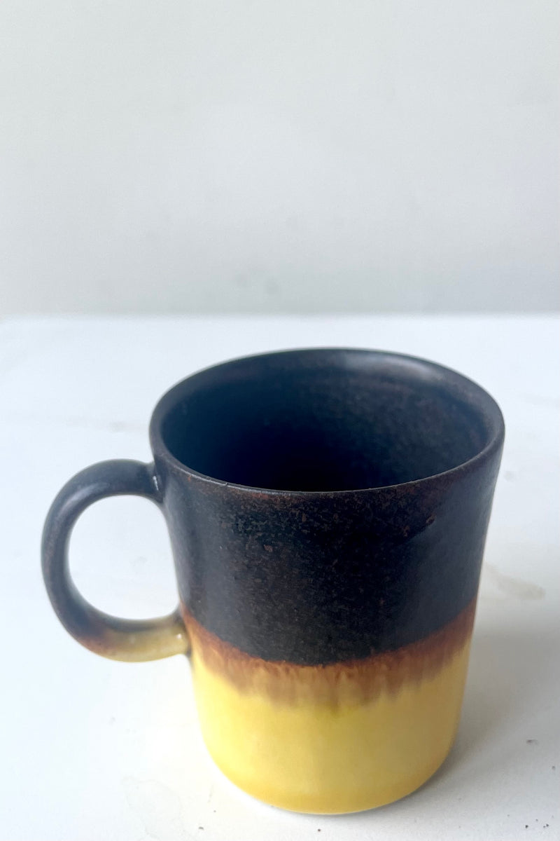 A slight overhead view of Espresso cup black & golden glaze against white backdrop