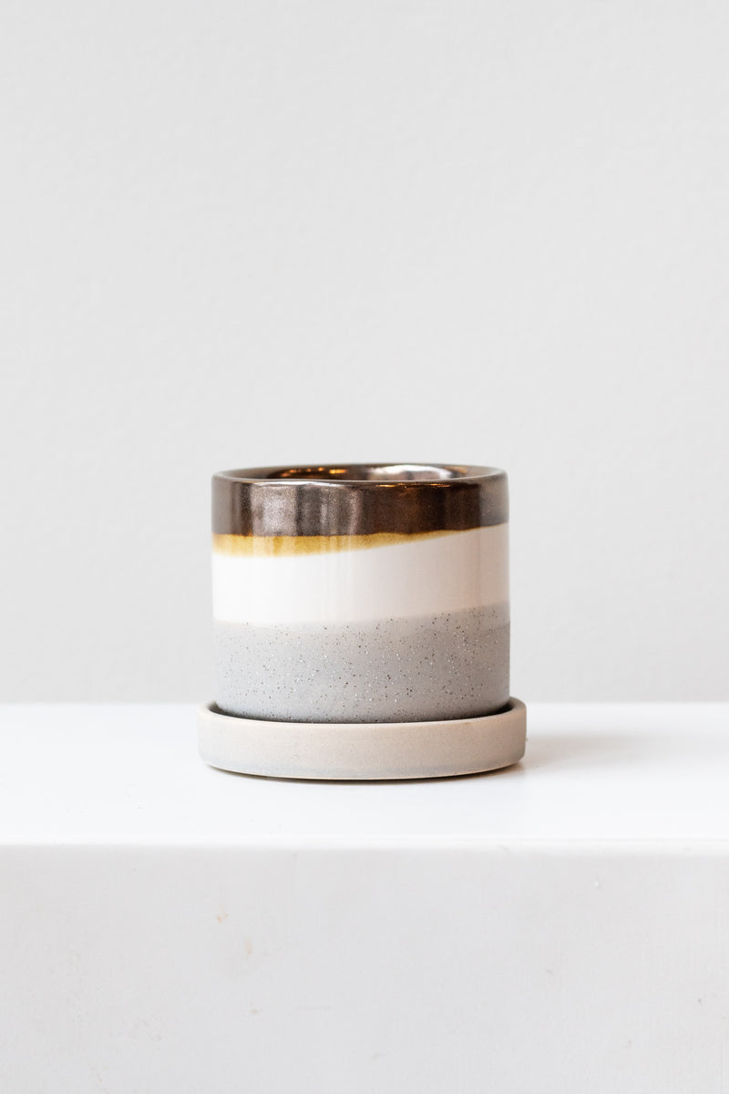 Small mocha cement Minute Pot sits on a white surface in a white room