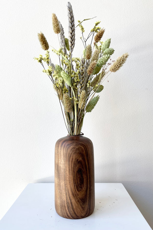 The Patti Walnut Large vase with dried floral against a white wall at Sprout Home. 