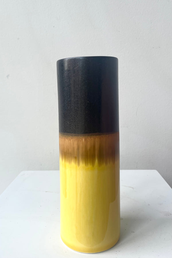 A full frontal view of Cylinder Vase black & golden against white backdrop