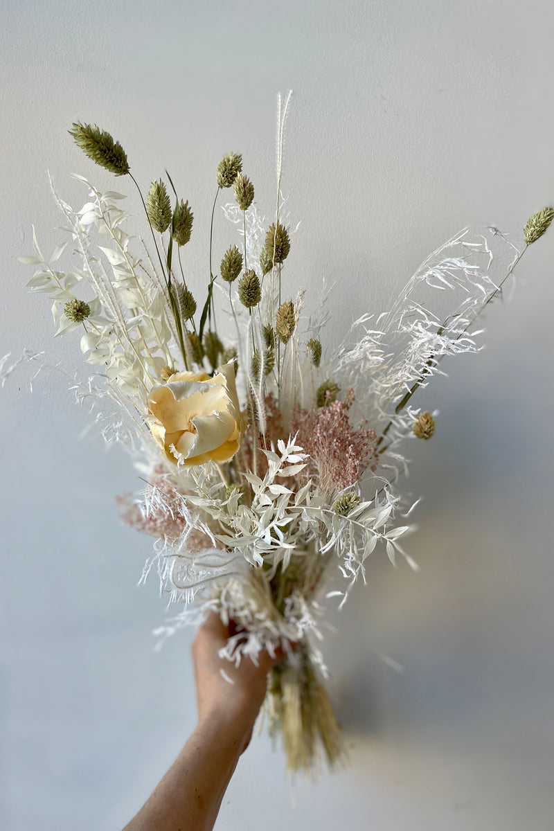 Small Pillow Talk dried preserved floral arrangement held in front of white background