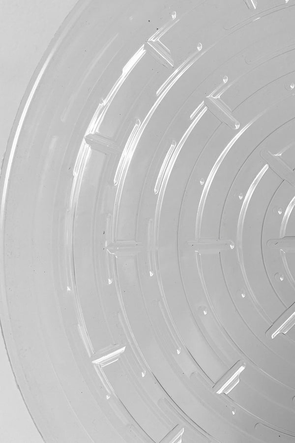 A detailed look at interior ridges of Plastic saucer 12" against white backdrop