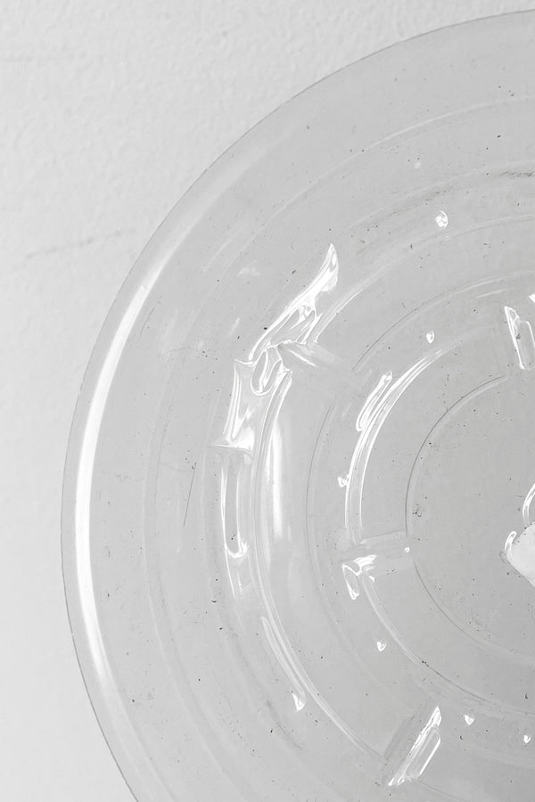 A detailed view of interior ridges of Plastic saucer 6" against white backdrop