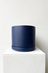 Solid Cylinder & Saucer blue 6” against a white wall