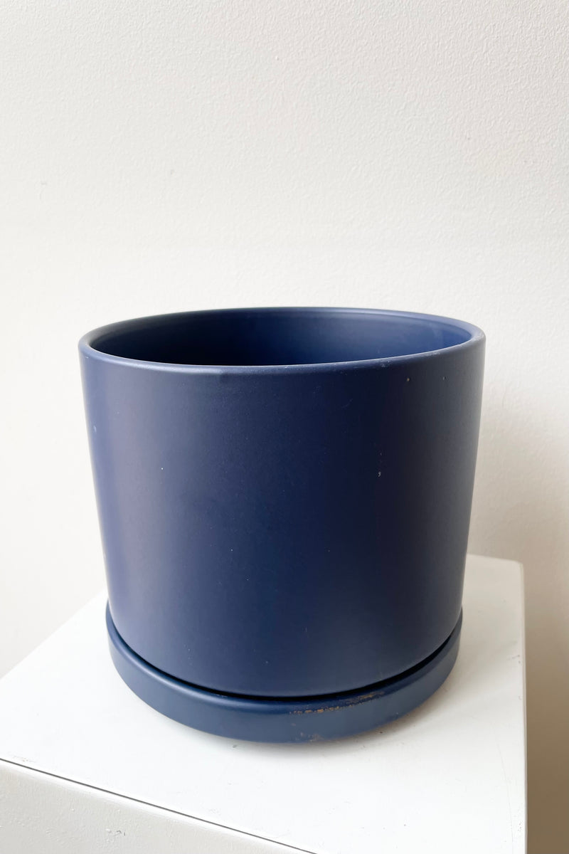 detail of Solid Cylinder & Saucer blue 6” against a white wall