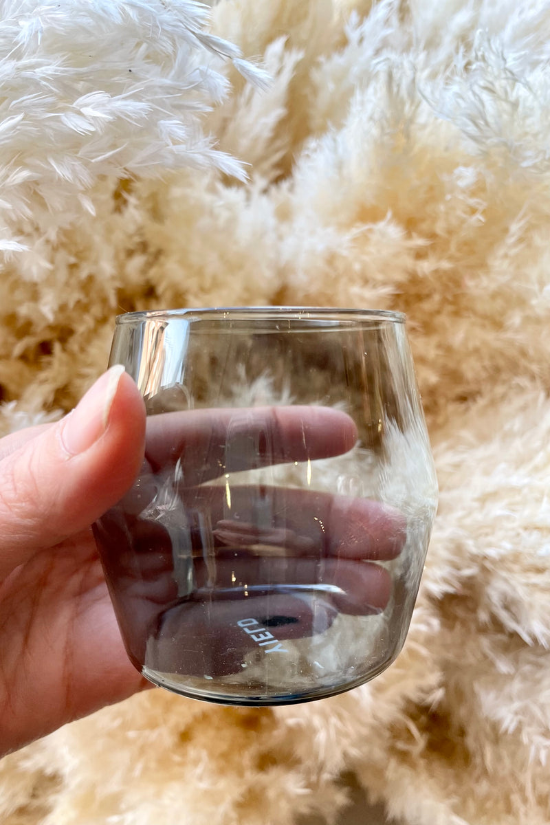 6oz grey century glass in hand against a pillowy background of pampas plumes.