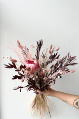 Sprout Home's Chocoberry preserved arrangement against a white wall. 