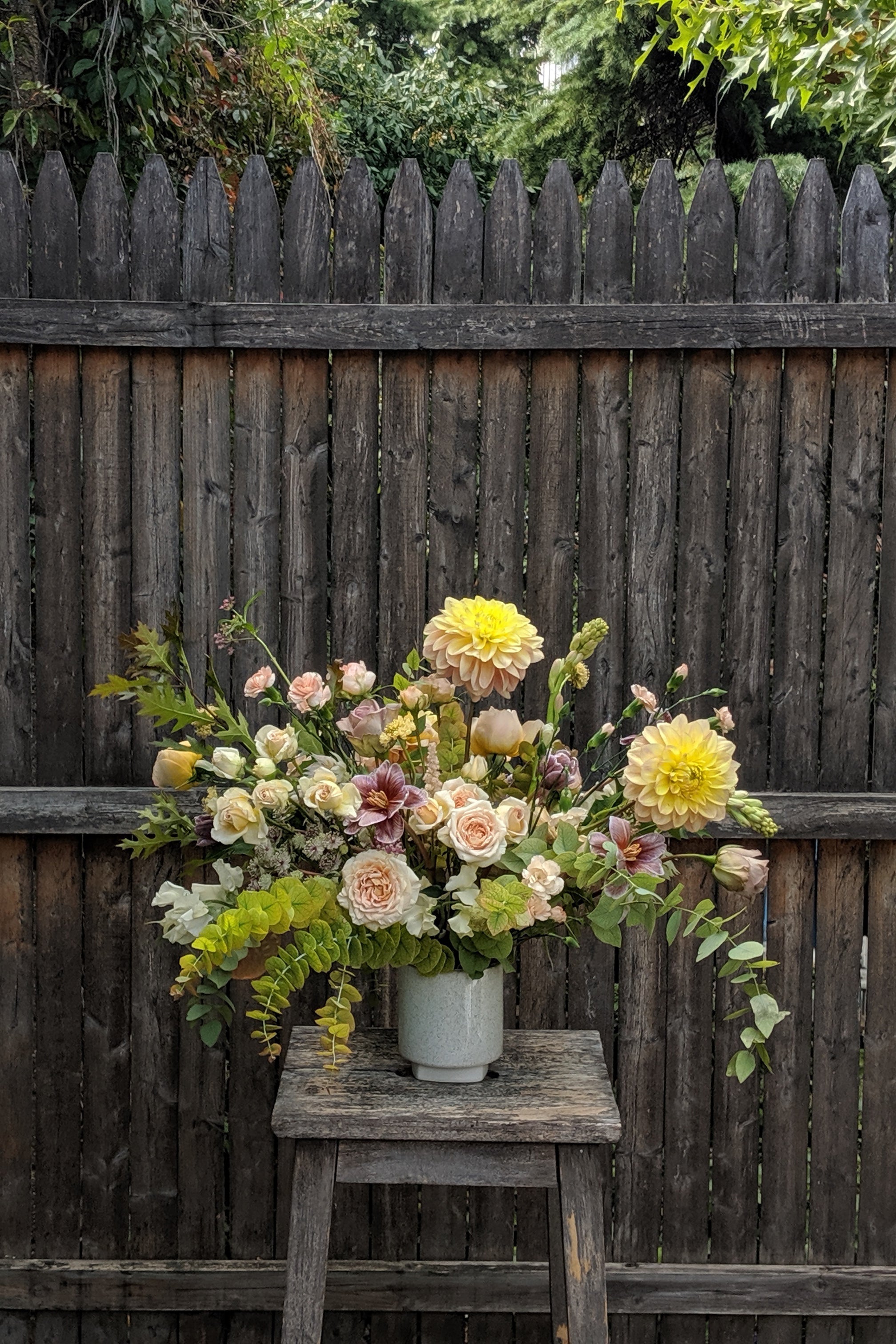 An example of Floral Arrangement Dawn from Sprout Home in Chicago. The arrangement is made of pastel yellow, purple, green, pink, and white flowers with green foliage. #size_$200