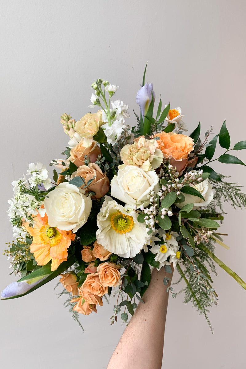 An example of Floral Arrangement Dawn from Sprout Home in Chicago. The arrangement is made of pastel yellow, purple, green, pink, and white flowers with green foliage.