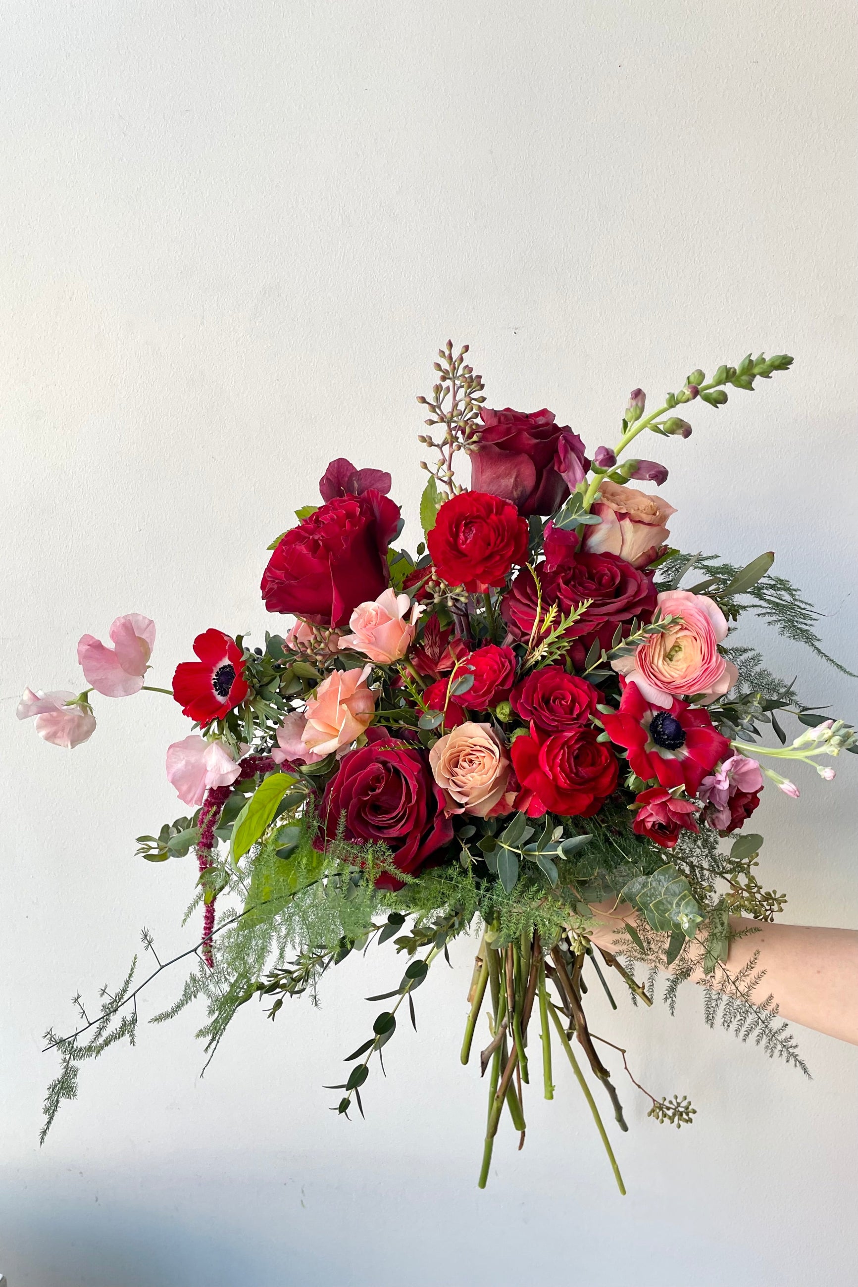 A hand holds an example of fresh Floral Arrangement Modern Lovefrom Sprout Home Floral in Chicago for Valentine's Day ©Sprout Home #size_$130