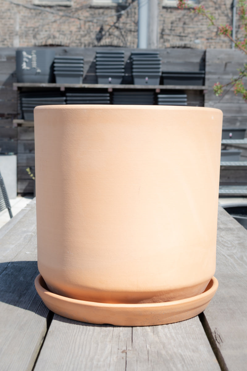 Buff clay 15 inch cylinder planter sits outside on a picnic table