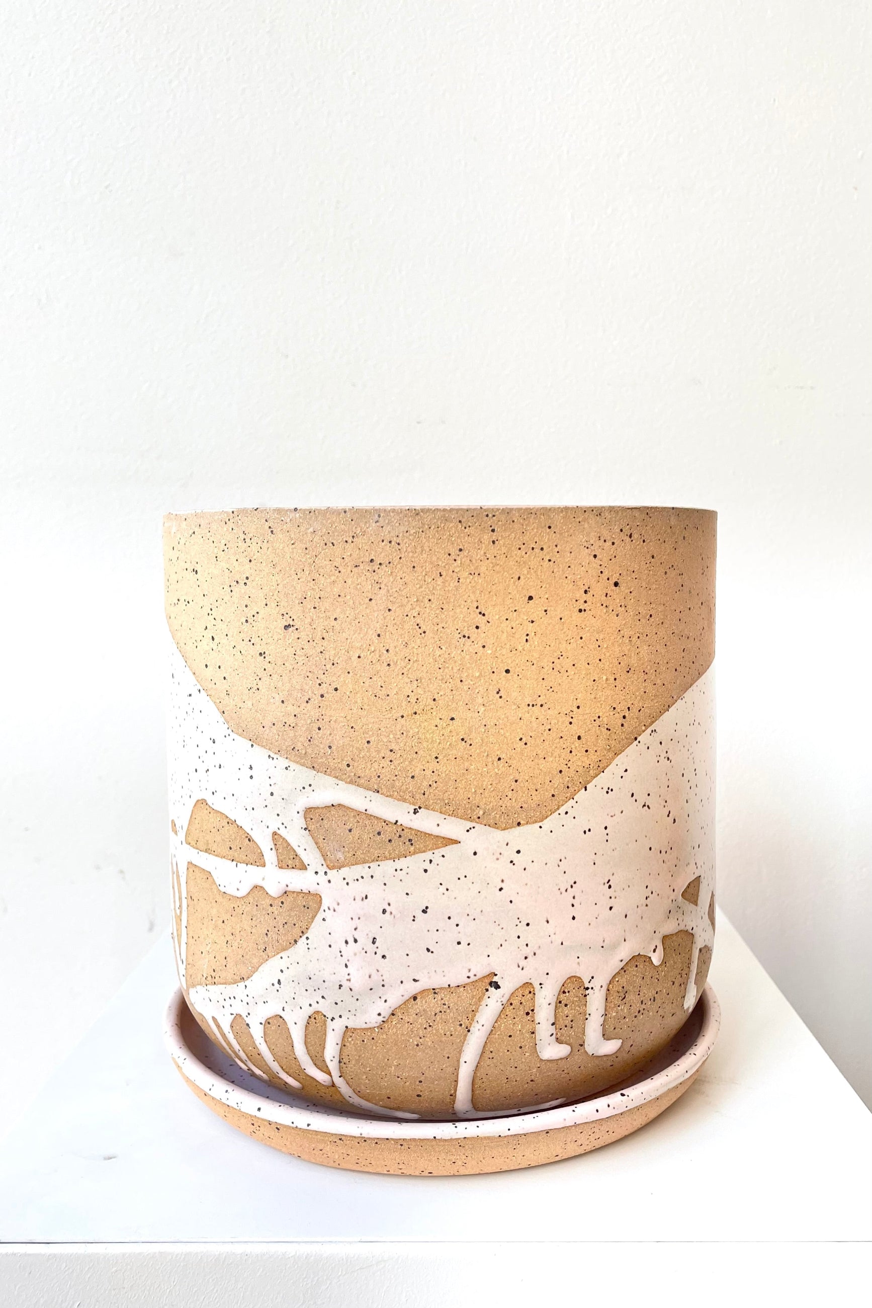 A frontal view of the 6.5" cylinder pot and saucer in pink against a white backdrop ©Sprout Home