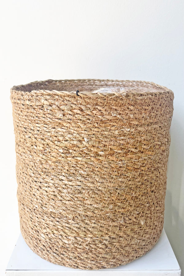 A slight over-the-lip view of Seagrass Basket with liner 10" against white backdrop