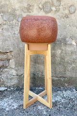 Sienna Reactive Glazed Pot & Wood Stand against a grey wall