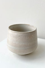 detail of the top of Marbled Stoneware pot vase beige against a white wall