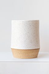 Megan Suave Ceramics large speckle stoneware vase on a white surface in a white room