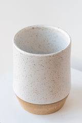 Megan Suave Ceramics large speckle stoneware vase on a white surface in a white room