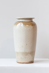 Bruning Pottery ivory and iron glazed tall ceramic vase in front of white background