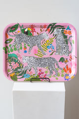 Pink leopard birch wood tray sits on a stand on a white podium in front of a white background