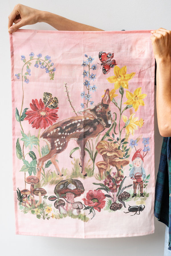 Person holding unfolded Bambi illustrated tea towel in front of white background