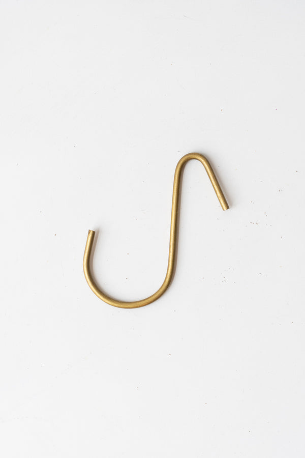 Small brass hook by Fog Linen in front of white background
