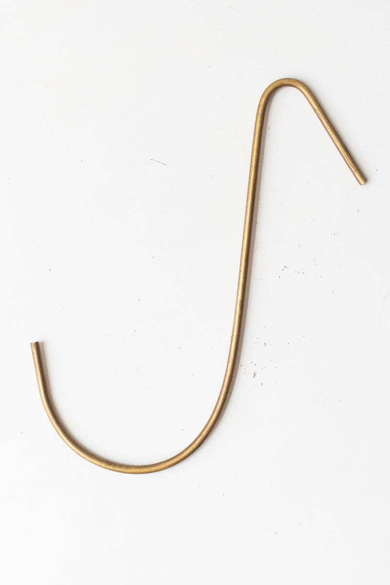 Large brass hook by Fog Linen in front of white background