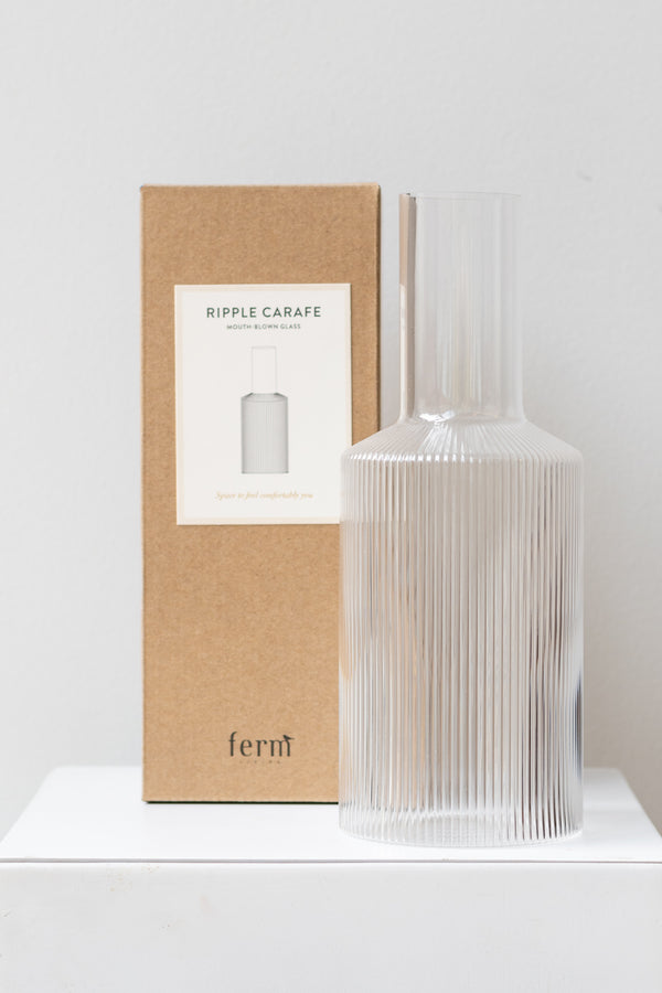 Ferm Living Ripple Carafe glass clear next to its box on a white surface in a white room
