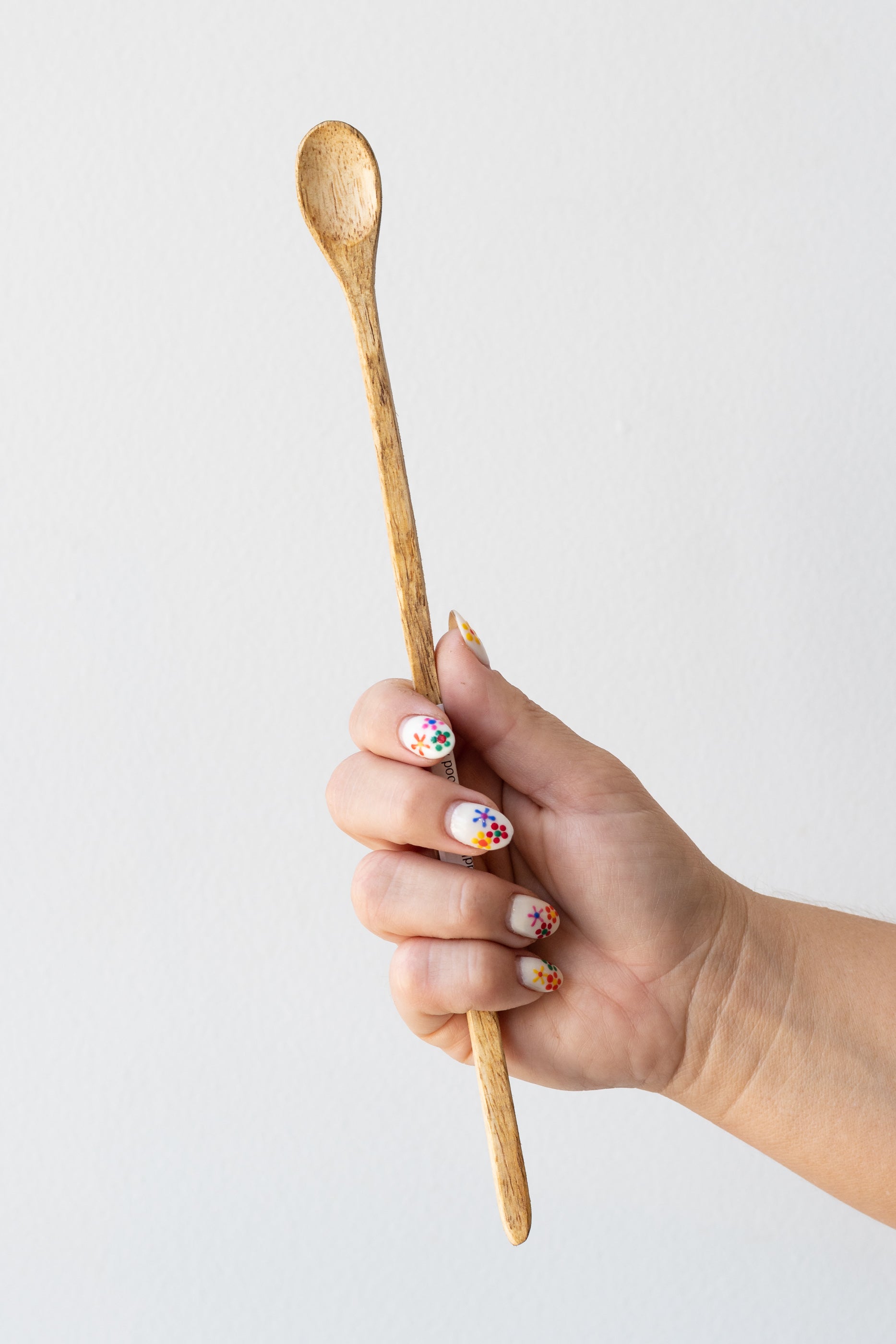 Fog linen work mango wood muddler spoon held in front of white background