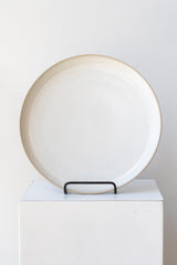 Ferm Living Sekki Plate cream large in iron stand on a white pedestal