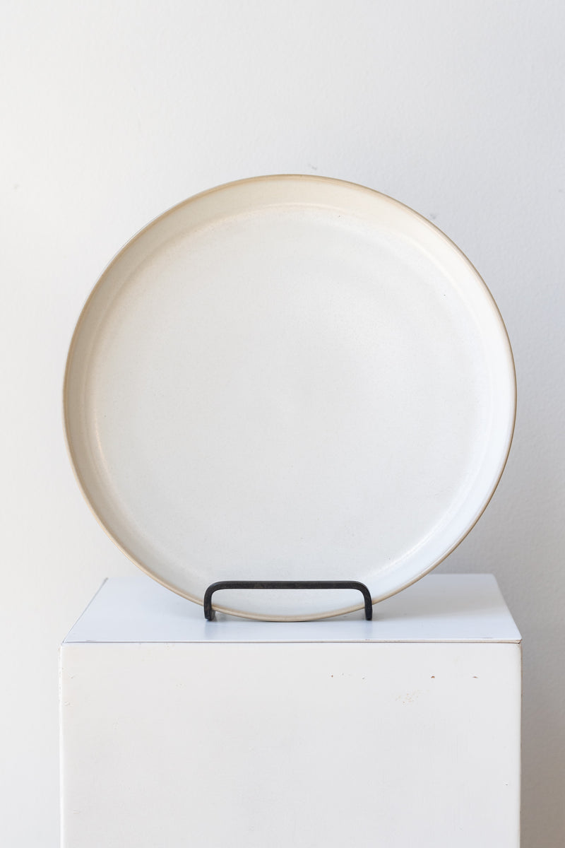 Ferm Living Sekki Plate cream large in iron stand on a white pedestal