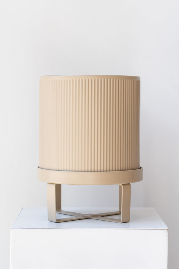 Small cashmere Bau Pot by Ferm Living on a white pedestal in front of white background