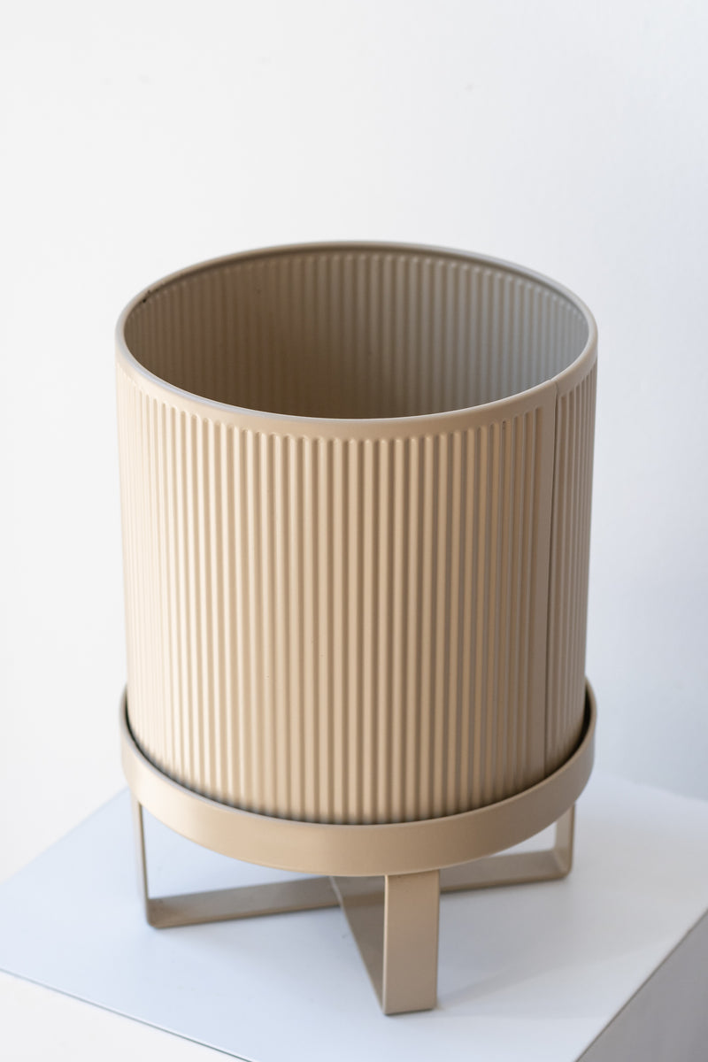 Small cashmere Bau Pot by Ferm Living on a white pedestal in front of white background