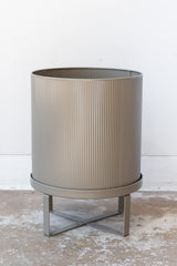 Large warm grey Bau Pot by Ferm Living on a concrete floor in front of white background