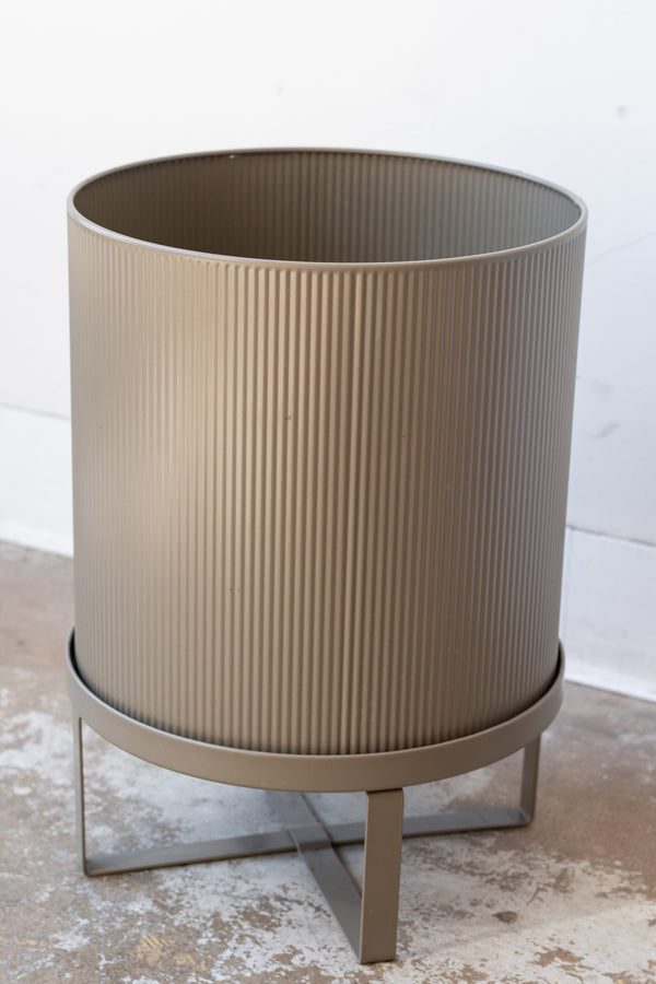 Large warm grey Bau Pot by Ferm Living on a concrete floor in front of white background