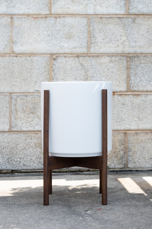 LBE Designs Stoneware Cylinder & Dark Teak Stand white 10” in front of concrete brick wall