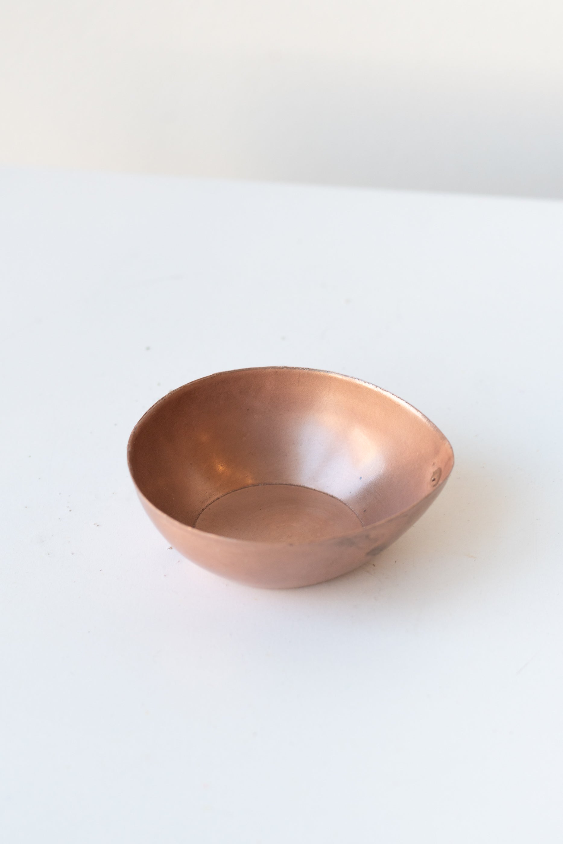 Alma Copper Tealight Holder on a white surface in a white room