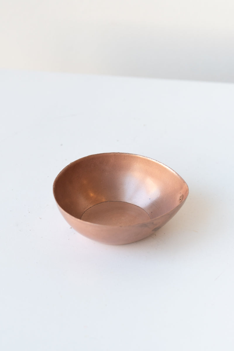 Alma Copper Tealight Holder on a white surface in a white room