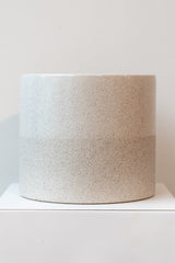 Two-tone stoneware speckled planter on a white surface in front of white background
