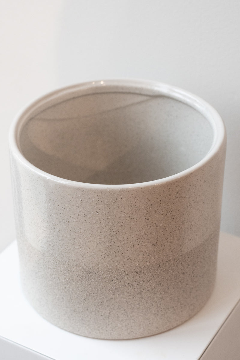 Two-tone stoneware speckled planter on a white surface in front of white background