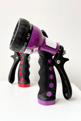 Dramm Touch 'N Flow Revolver Sprayer in purple and red against a white wall